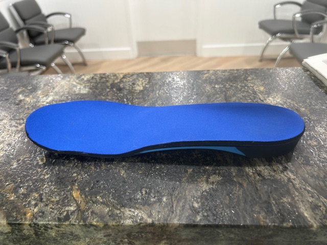 Custom orthotics mold with foot impression in blue material from Foot, Ankle & Leg Vein Center.